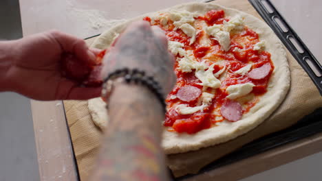 adding mozzarella to pepperoni pizza