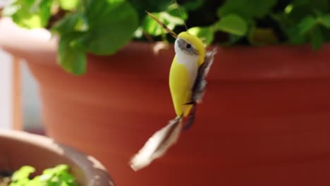 toy bird in flowerpot flapping wings