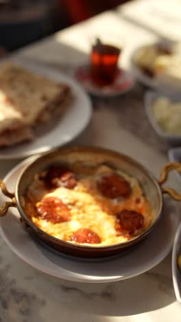 turkish breakfast with eggs, sausage, and bread