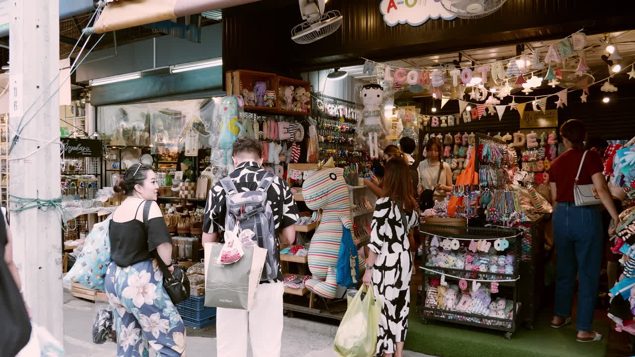 People walk the vibrant bustle in Bangkok's Chatuchak Market with locals and foreigners shopping in Bangkok, Thailand