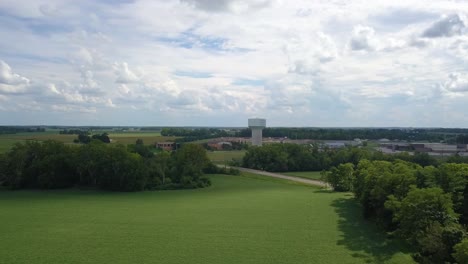 vista aérea que orbita la torre de almacenamiento de suministro de agua en terre haute rural green farmland, indiana