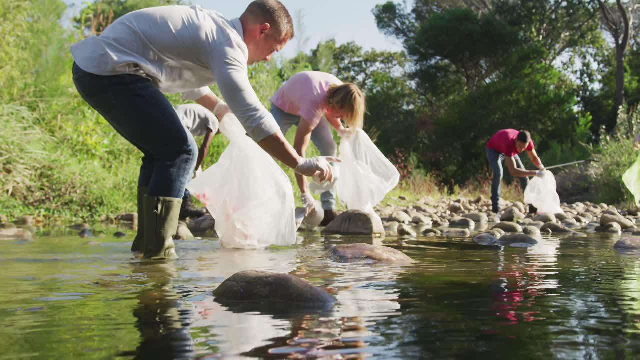 Adultos de mediana edad haciendo voluntariado durante el día de limpieza del río