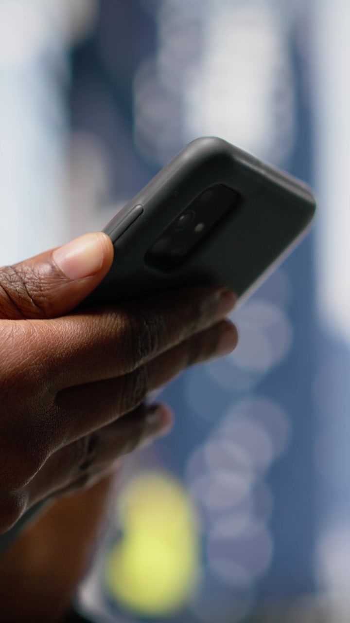 Vertikal video: Nærbillede af fodgænger, der skriver tekstbeskeder på sin smartphone.