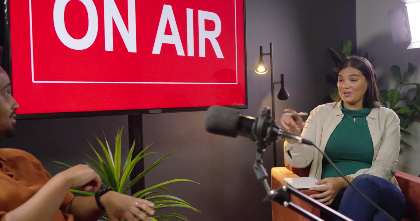 Conduttori africani che parlano in studio dopo l'accensione della luce ON AIR con una tazza, controllando l'orologio, registrando con i microfoni