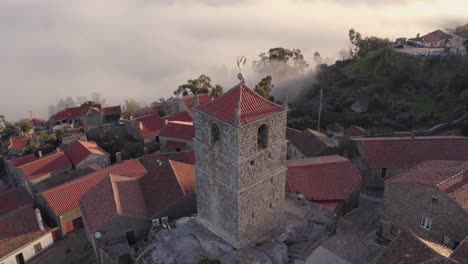 Campanario-De-Monsanto-Portugal-Con-Nubes-Bajas-Durante-El-Amanecer,-Antena