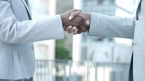 slow motion shot of business partners shaking hands outdoor