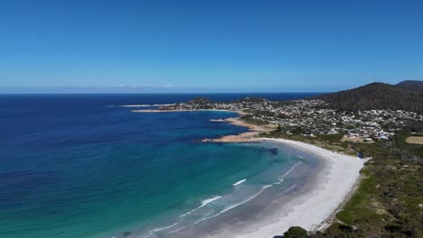 wide panoramic view of the white sandy beach and the town of bicheno in tasmania, australia