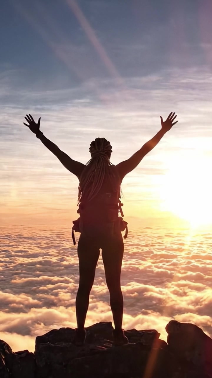 Il trionfo di un avventuriero: una silhouette contro l'orizzonte luminoso mentre il sole tramonta su un oceano di nuvole, celebrando lo spirito di conquista e libertà.