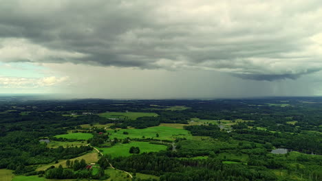 Nach-Unten-Geneigte-Luftdrohnenaufnahme-über-Einer-Wunderschönen-Ländlichen-Landschaft-Mit-üppiger-Grüner-Vegetation-Und-Einem-Kleinen-See,-Der-An-Einem-Bewölkten-Tag-Sichtbar-Ist