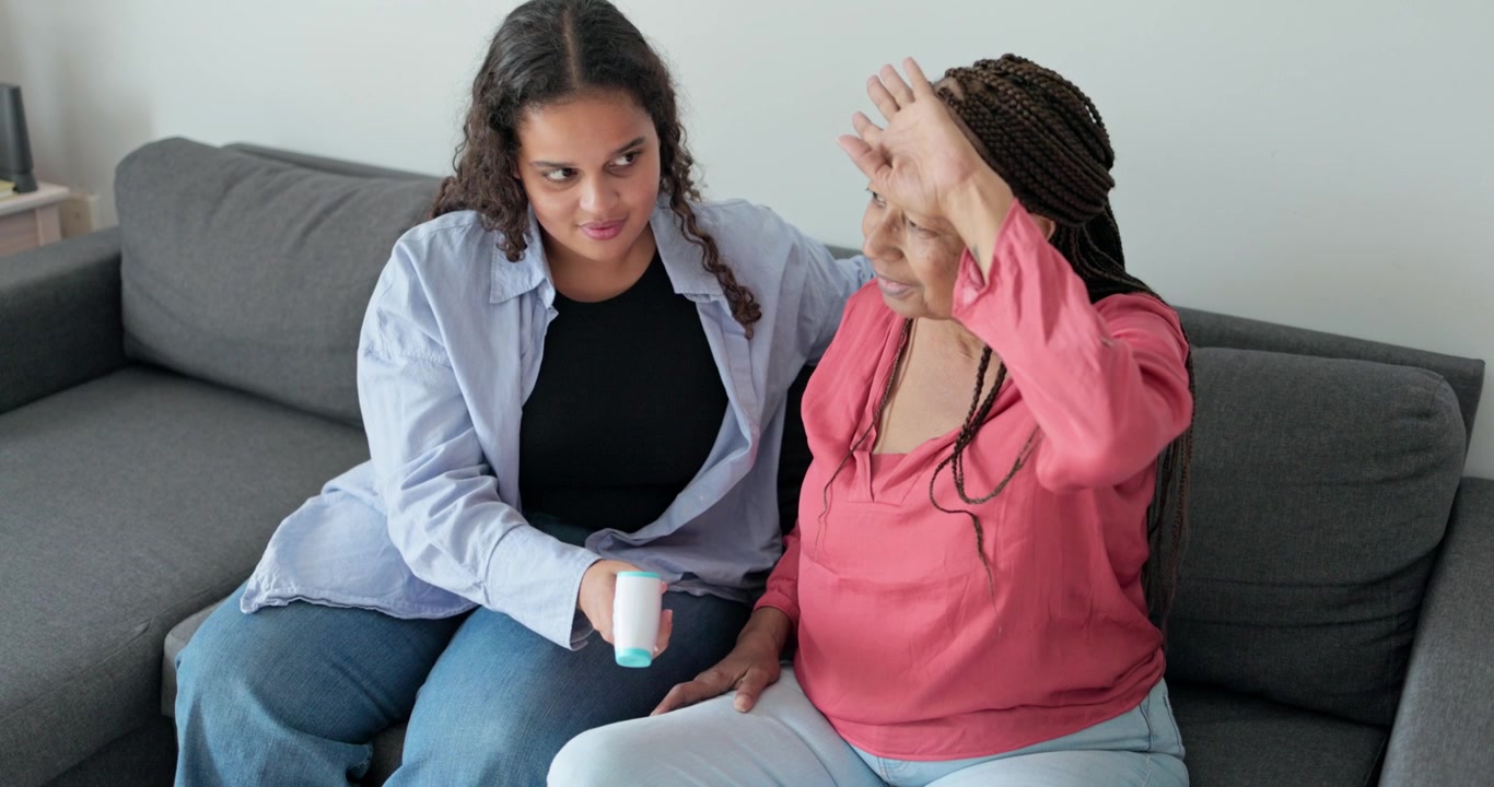 Jovem ajudando mulher idosa com dispositivo médico em casa