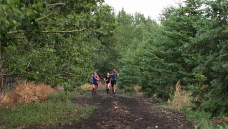 Vista-Frontal-De-Personas-De-Raza-Mixta-En-Forma-Corriendo-En-Un-Sendero-En-El-Bosque-4k