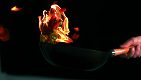 Chef-tossing-flaming-pan-of-peppers-