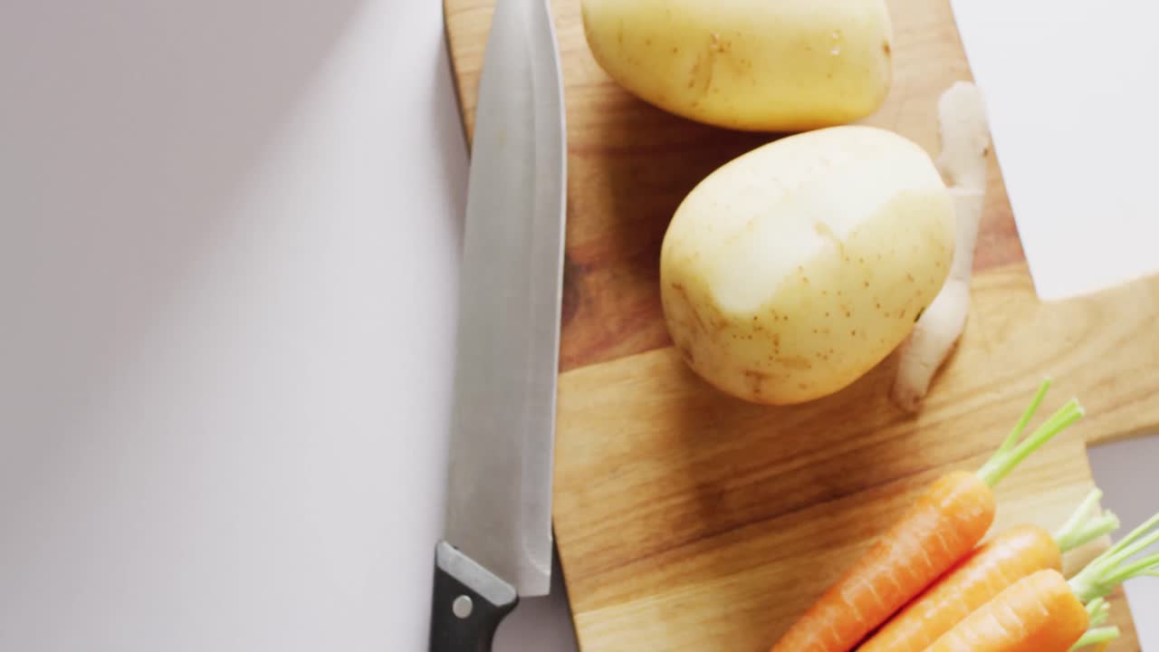 video aéreo de cuchillo y verduras en la tabla de cortar, con residuos de verduras en un contenedor para compostar.