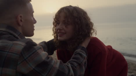 romantic couple kissing on beach at sunrise. girl and guy hugging each other