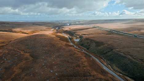 aerial drone, cinematic footage of a country winding road on saddleworth moor, greater manchester, uk