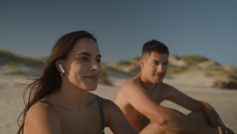 una pareja joven tomando el sol en la playa.