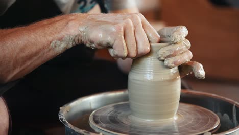 ceramist uses potter's wheel and creates a handmade clay product