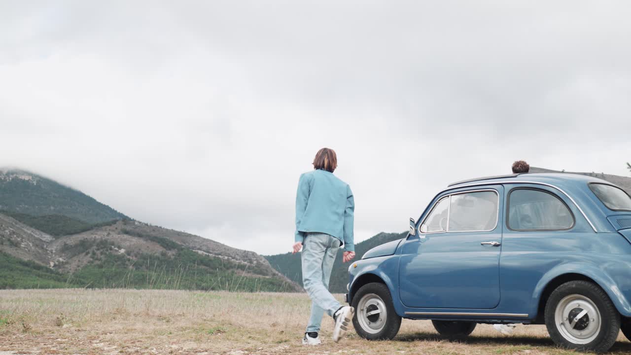 Two men step out of a car in a scenic outdoor setting. Freedom, adventure, road trip, lifestyle concept.