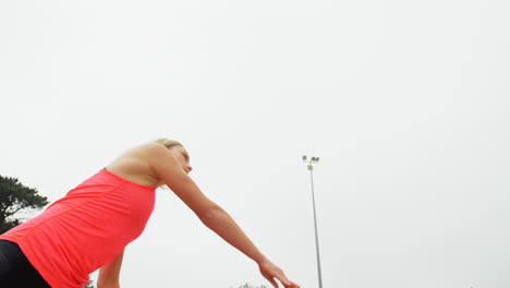 Low-angle-view-of-Caucasian-female-athlete-practicing-javelin-throw-at-sport-venue-4k