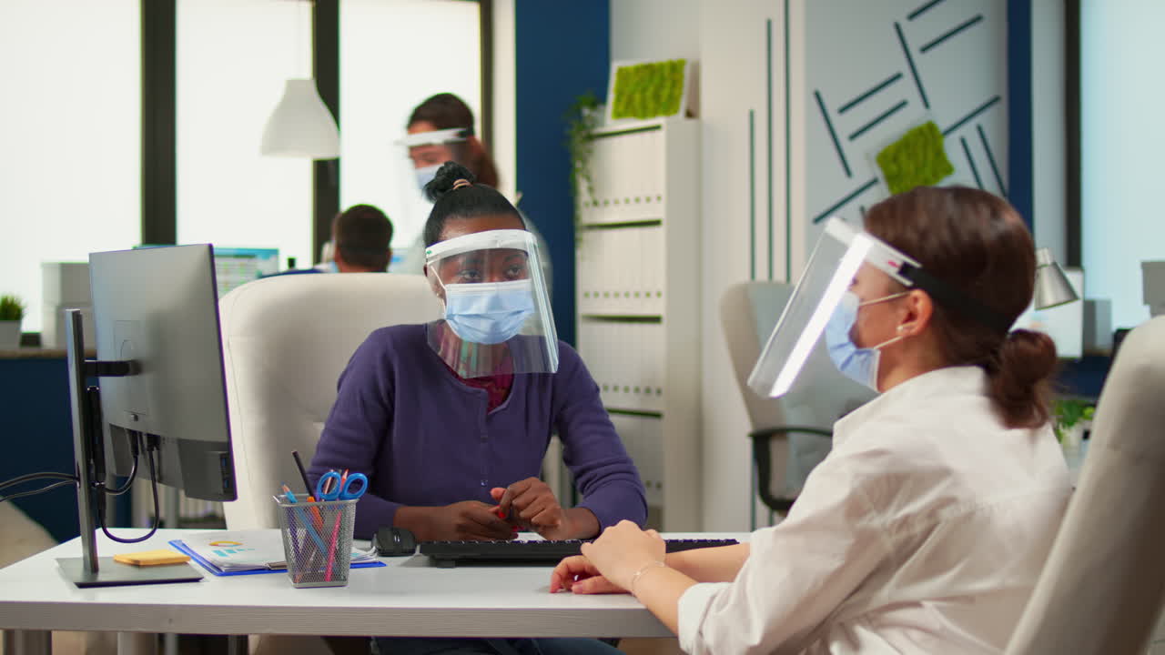 다민족 파트너가 사무실에서 일하고 새로운 정상으로 책상에 앉아 있습니다.