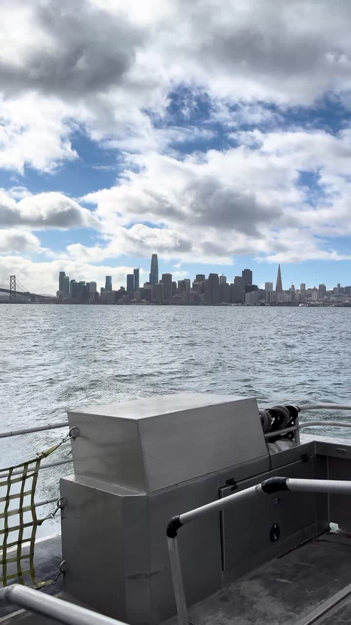 A panning shot from a moving ferry across San Francisco Bay, showcasing the iconic skyline and waterfront from an iPhone perspective. It is a stunning blend of city and coastal scenery.