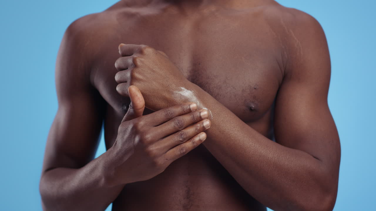 hombre aplicando loción en su brazo
