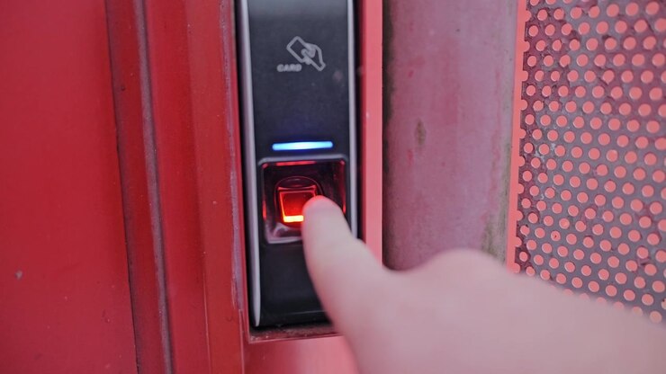 Finger activates biometric access as electronic security unlocks snowy entrance