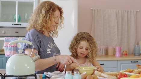 mother and daughter cooking together in the kitchen