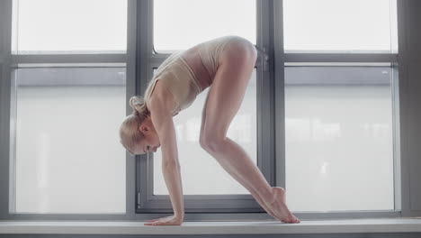 woman doing yoga poses by the window