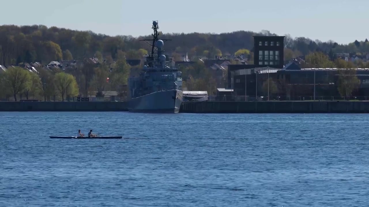 ドイツで軍艦の前にいる2人の漕ぎ手の手漕ぎボート 4K 60p