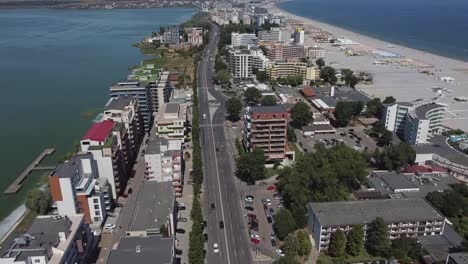 Approaching-drone-shot-of-a-strip-of-land-where-hotels,-condominiums,-restaurants,-and-other-entertainment-establishments-are-located,-at-the-beachfront-of-Mamaia-resort,-in-Constanta,-Romania