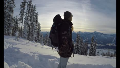mujer caminando por una ladera de montaña cubierta de nieve 4k