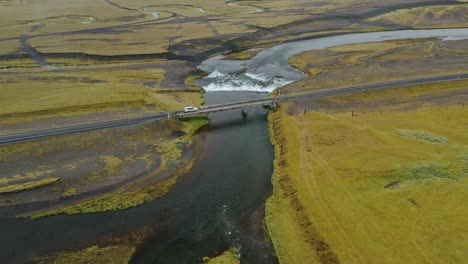 aerial drone footage of car drives on the bridge over the river in iceland.