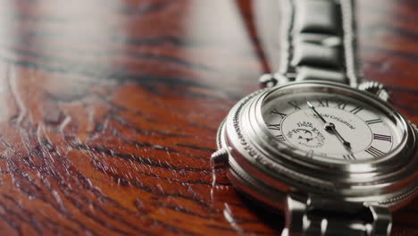 elegant silver wristwatch on wooden table