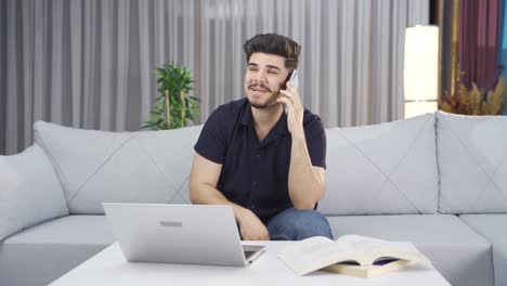 un joven feliz hablando por teléfono.