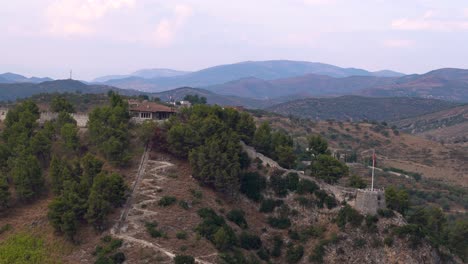 view out towards berat castle with flag and viewpoint and mountain range in background