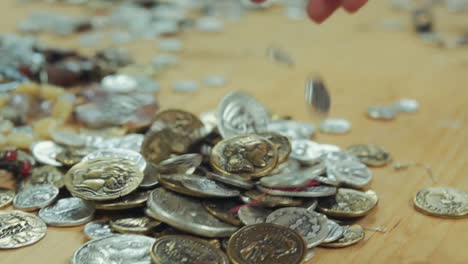 handful-of-coins,-treasure,-money,-being-dropped-on-a-table