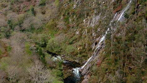 rio sor en el fondo del valle rocoso con una violenta cascada cayendo desde la cumbre