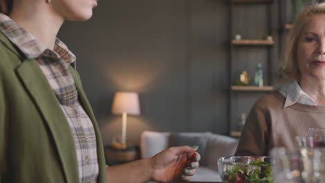 Close-Up-Of-Mother-And-Daughter-Holding-Hands-And-Praying-Before-Meal-At-Home