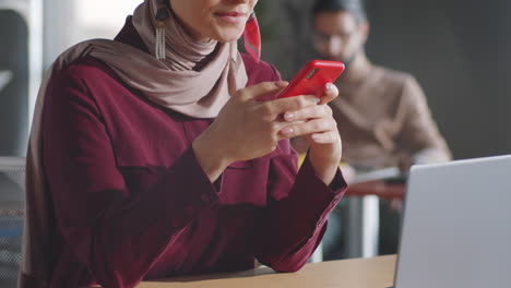Muslimische-Geschäftsfrau-Benutzt-Smartphone-Und-Lächelt