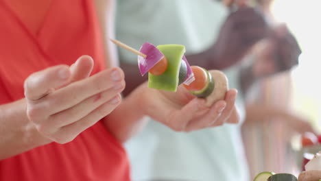 hands prepare fresh vegetable skewers in a home kitchen