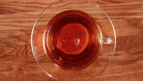overhead view of tea with lemon slice on a wooden table