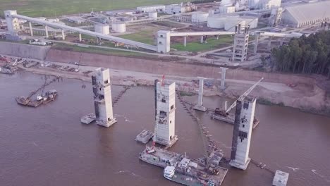 Aerial View of the Factory at the edge of the river carrying grains in a freighter