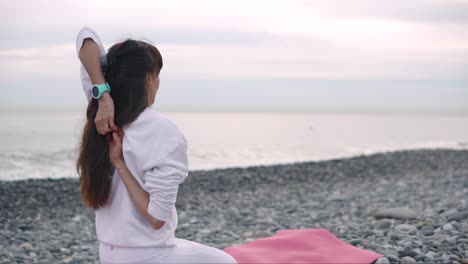 woman practicing yoga on a beach at sunrise/sunset