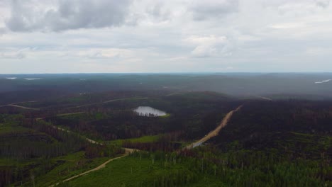 Vista-Aérea-Deslizante-De-Derecha-A-Izquierda-De-La-Gran-Extensión-De-Tierras-Boscosas-Quemadas-Hasta-Los-Cimientos-En-Canadá-Durante-Un-Incendio-Forestal-Masivo