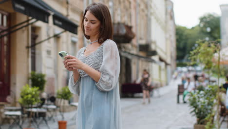 Una-Mujer-Viajera-Turista-Que-Usa-Un-Teléfono-Inteligente-Para-Buscar-Un-Camino-En-El-Mapa-En-La-Aplicación-De-Navegador-Móvil