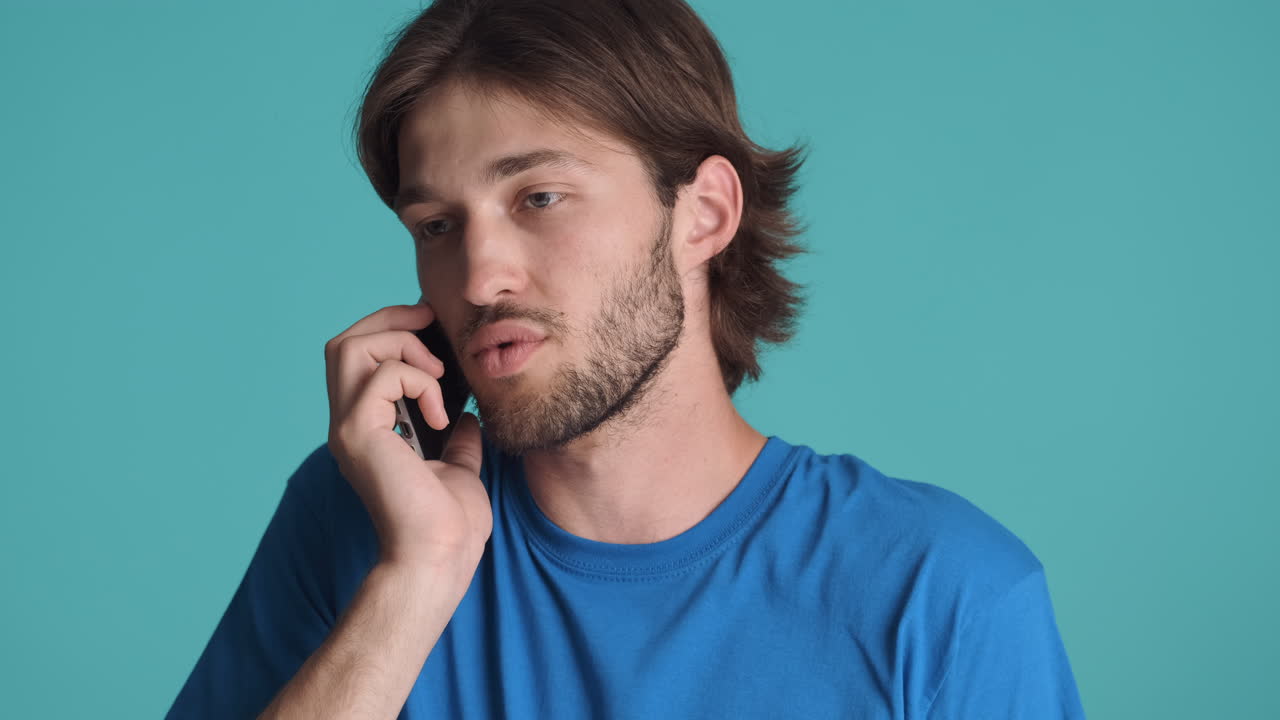 Caucasian man in front of camera on blue background.