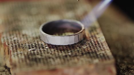 Close-up-of-shaping-ring-with-blowtorch-in-workshop-in-slow-motion