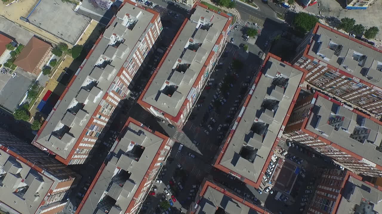 Plano aéreo de cima para baixo com drone avançando sobre os telhados de Málaga e as ruas da cidade
