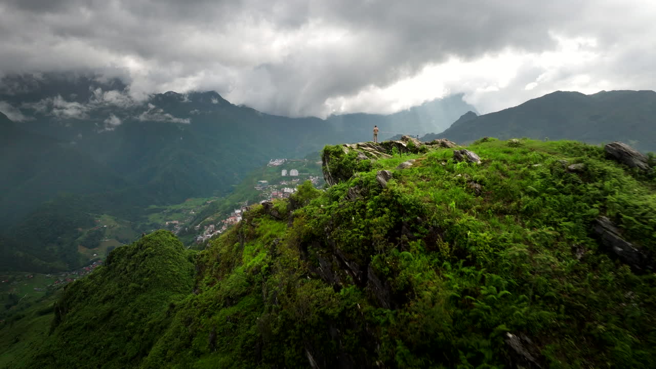 Man stand on Ham Rong mountain overlooking scenic Sapa town with karst mountains